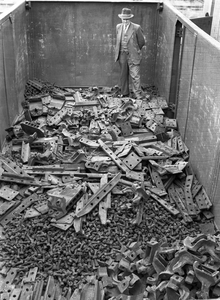 858599 Afbeelding van een open goederenwagen met allerlei losse spoorbevestigingsmaterialen op het terrein van de ...